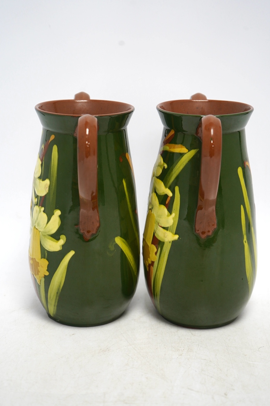 A pair of Watcombe Torquay vases decorated with daffodils, 20cm high. Condition - good